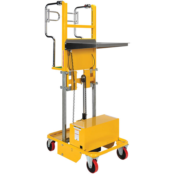 A yellow Vestil electric order picker with a metal box on the platform.