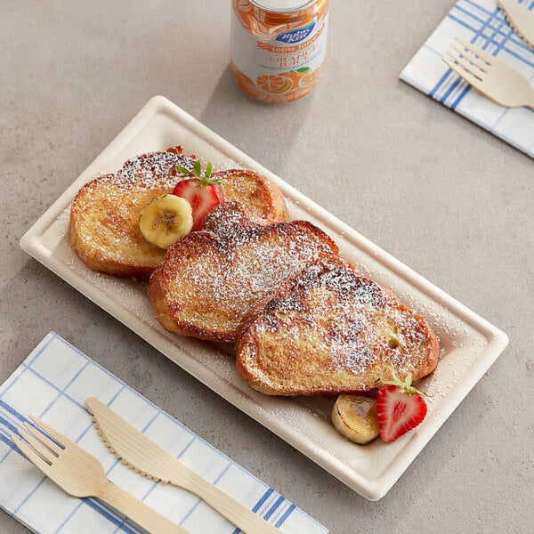 A EcoChoice natural bagasse rectangle plate with french toast, bananas, and powdered sugar on it.