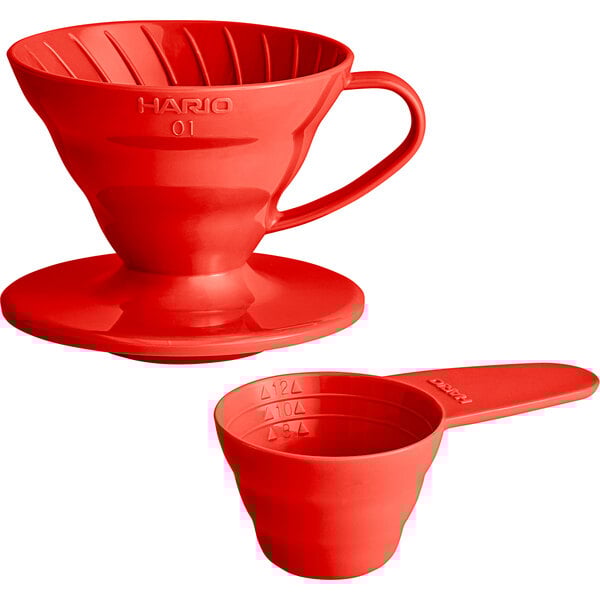A red plastic coffee dripper with a measuring spoon.