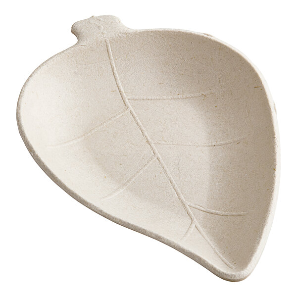 A white leaf shaped dish with a small leaf on it.