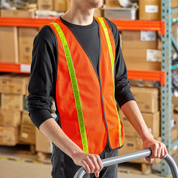 A man in an orange Lavex safety vest holding a hand truck.