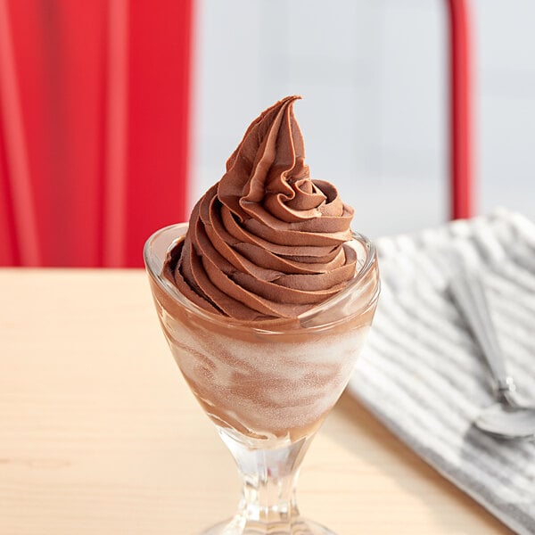 A glass with chocolate soft serve ice cream.