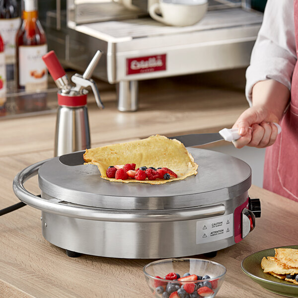 A woman using the Estella portable crepe maker to make a crepe.