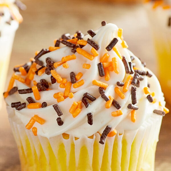 A cupcake with white frosting and Halloween sprinkles.