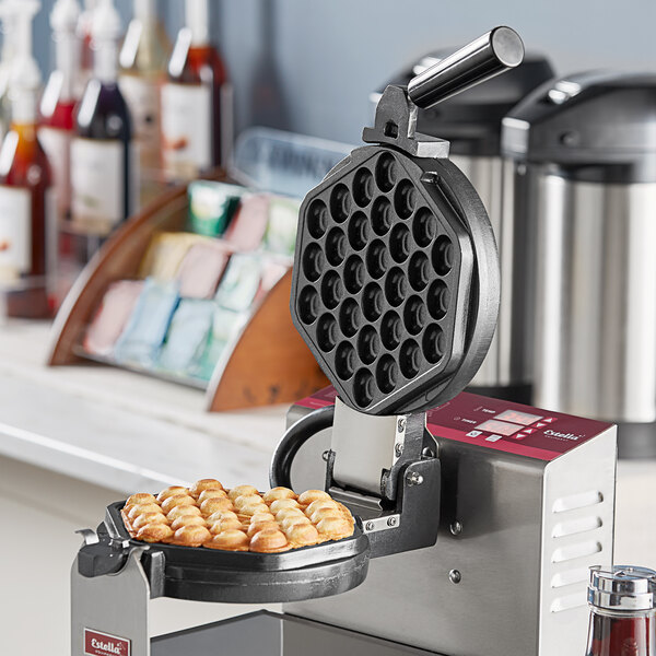 An Estella bubble waffle plate in a waffle maker machine with food on it.