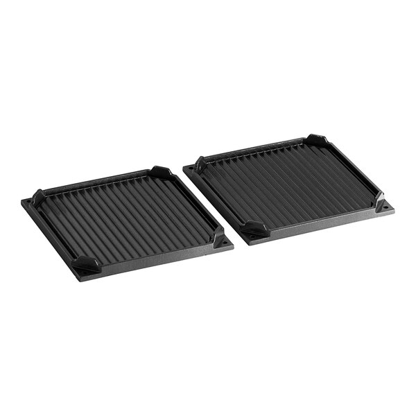 A pair of black square grill pans with black grill plates on a table.