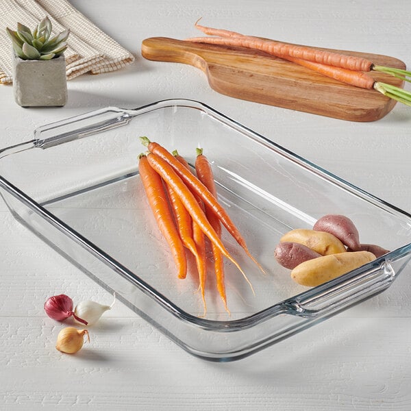 A clear glass rectangular baking dish with handles on each end.