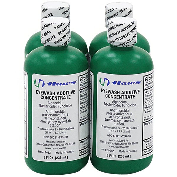 A close-up of a group of green Haws eyewash water additive bottles with white labels.