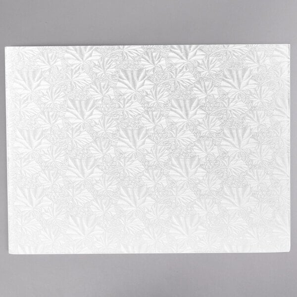 A white rectangular Enjay cake board with floral designs on it.