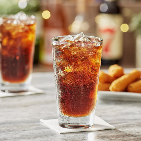 A glass of Acopa Select iced tea with ice on a table.