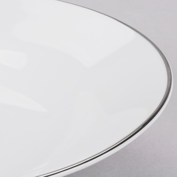 A white porcelain soup bowl with a silver rim.