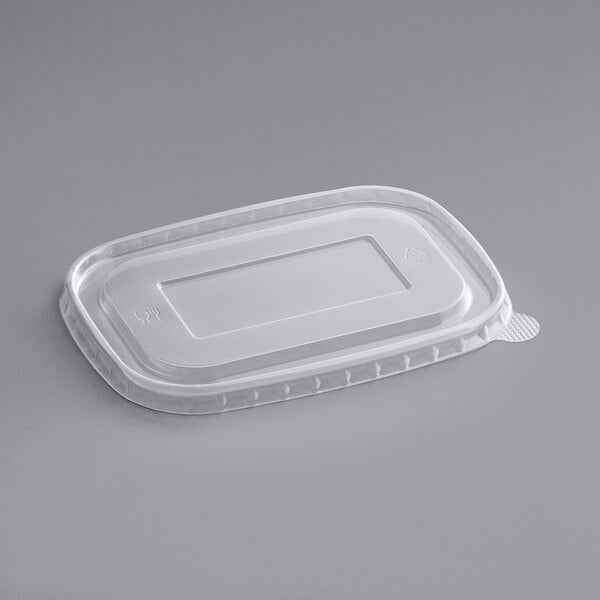 A rectangular clear plastic lid on a gray surface.