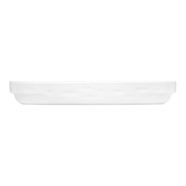 A white, shallow, oval-shaped dish viewed from the side.
