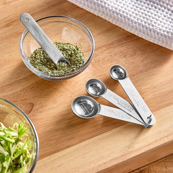 An American Metalcraft stainless steel measuring spoon in a bowl of seasoning.