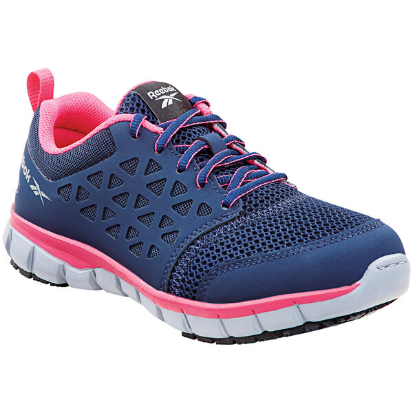 A close up of a navy and pink Reebok Work Sublite women's athletic shoe.