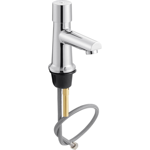 A silver Chicago Faucets metering sink faucet with a gold handle.