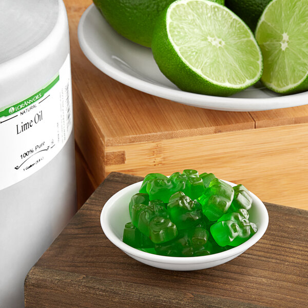 A jar of lime jello with a spoon next to it on a counter.