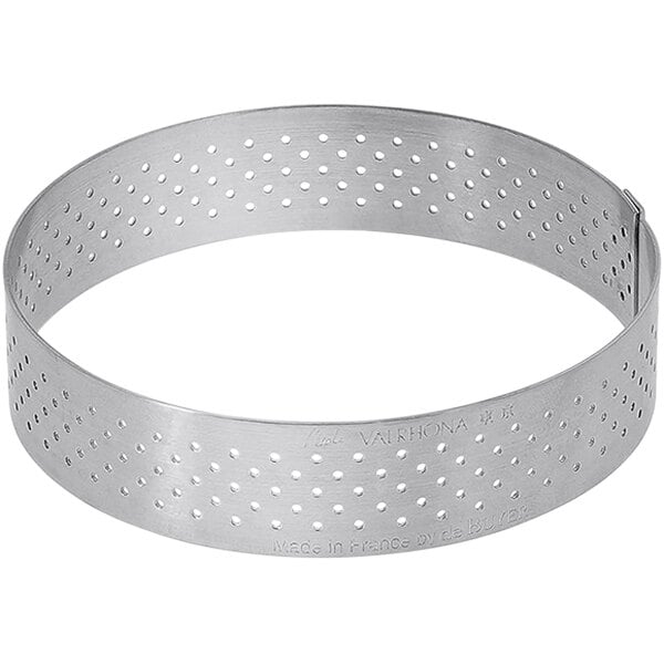 A silver stainless steel circular tart ring with perforations.