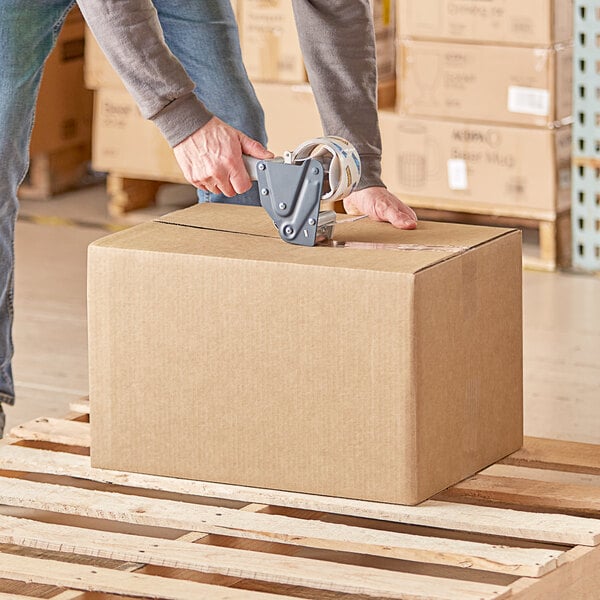 A person using a box cutter to cut a Lavex shipping box.