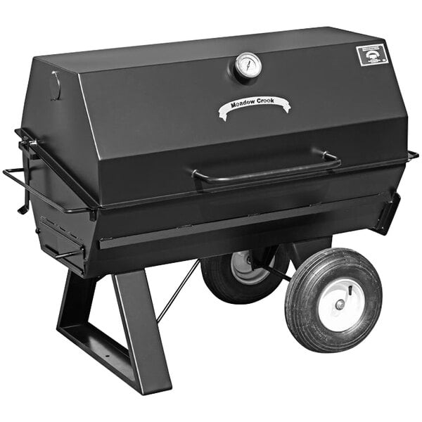 A black Meadow Creek charcoal pig roaster on wheels.