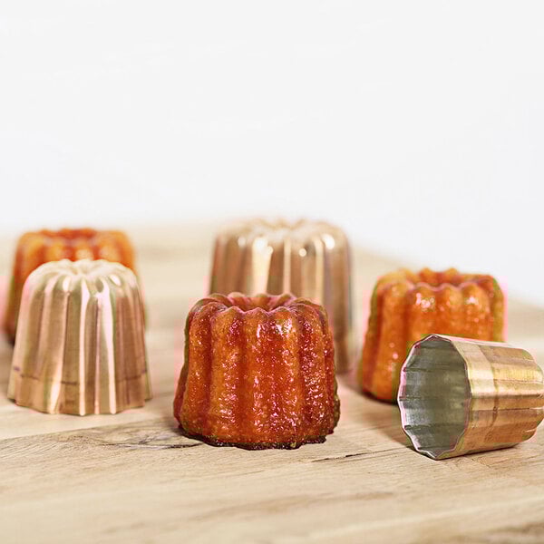 A close-up of a copper cannele mold.