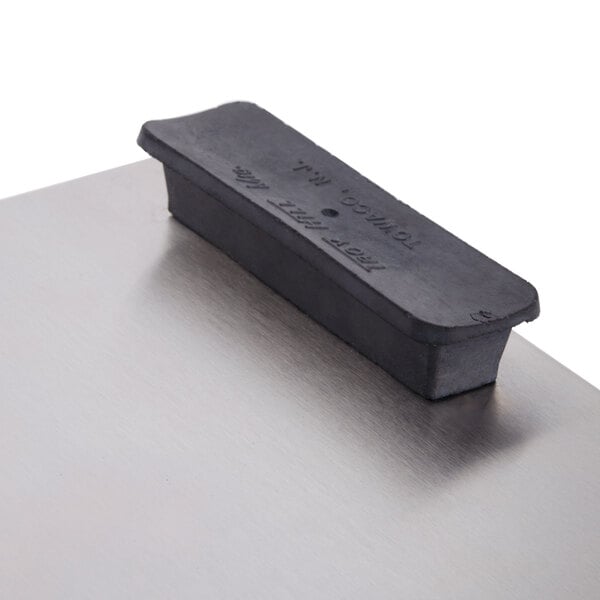 A black rectangular rubber pad with text on a metal surface.