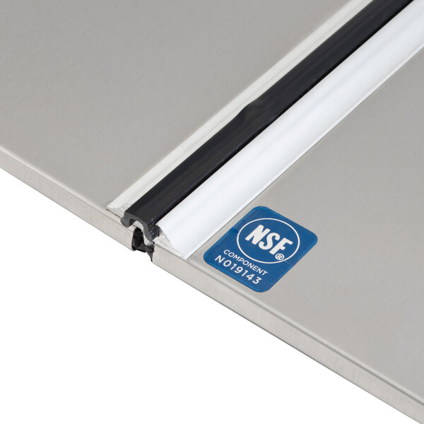 A stainless steel Assure lid for a commercial ice cream freezer.