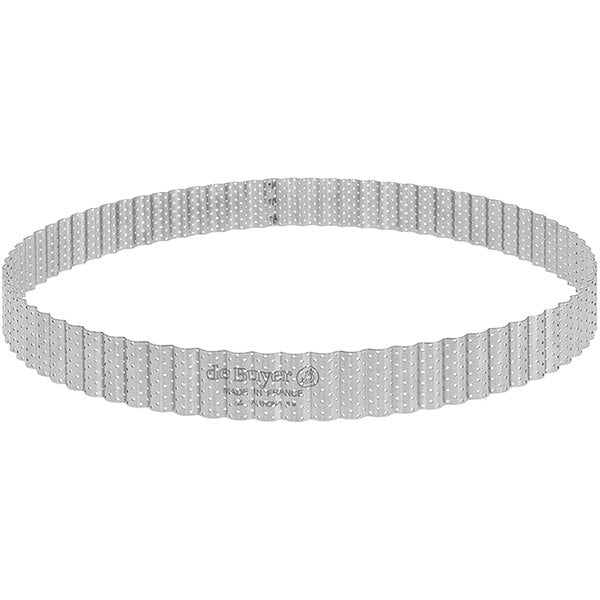 A close-up of a de Buyer stainless steel round fluted tart ring with holes.