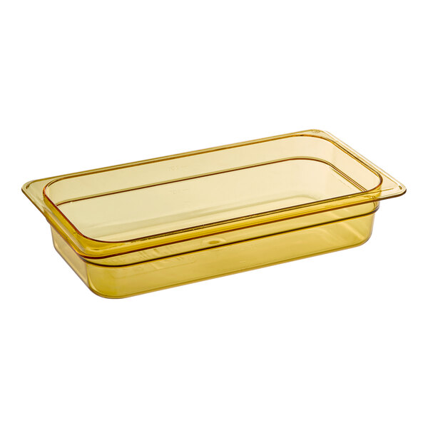 A Carlisle amber rectangular plastic food pan on a counter.