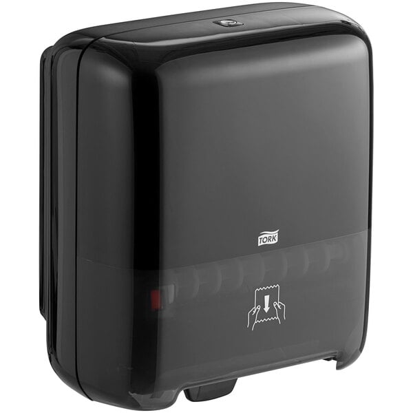 A black Tork Elevation Matic hands-free paper towel dispenser on a counter with a white label.