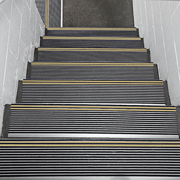A set of stairs with black and yellow striped safety treads.