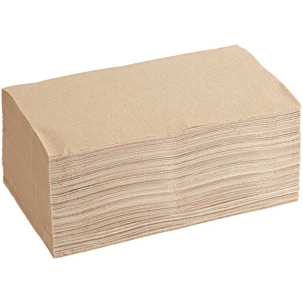 A large stack of Tork natural kraft brown paper towels.