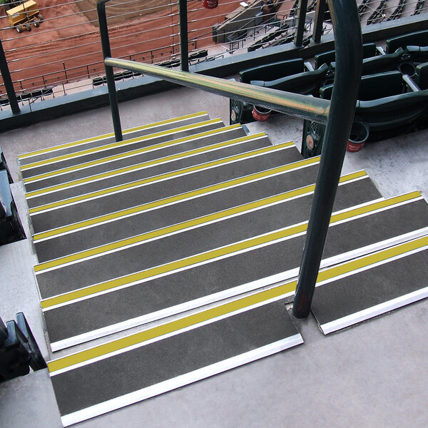A set of stairs with yellow and black stripes using Wooster Flexmaster stair treads.