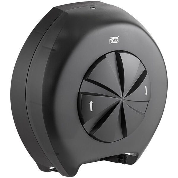 A black circular Tork toilet paper dispenser with a circular button.