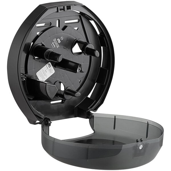 A black plastic Tork toilet tissue dispenser with a lid.
