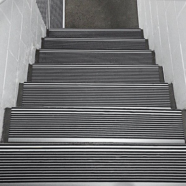 A close-up of a staircase with black Wooster Stairmaster treads.
