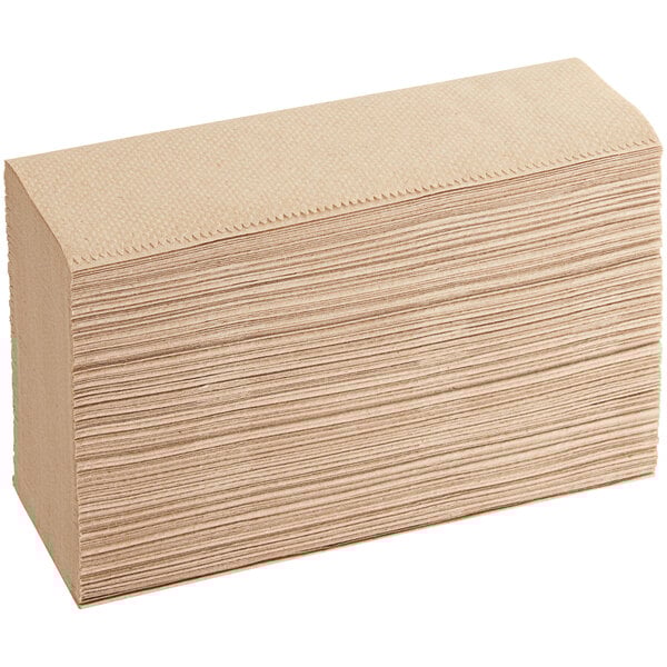 A large stack of Tork natural kraft multi-fold paper towels.