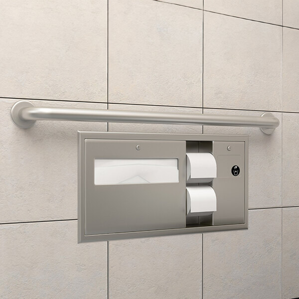 A Bobrick grey metal grab bar in a bathroom with a toilet paper dispenser and a towel rack.