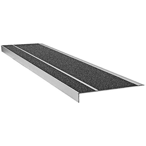 A close-up of a rectangular black metal stair tread with black and white grit surface strips.