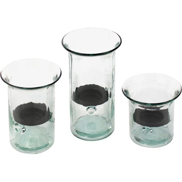 Three glass cylindrical hurricane candle holders with black metal inserts.