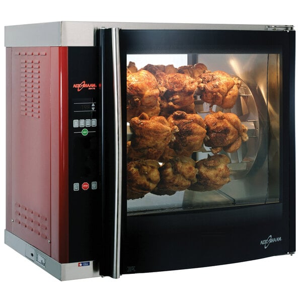 A large Alto-Shaam rotisserie oven with cooked chickens on spits inside.