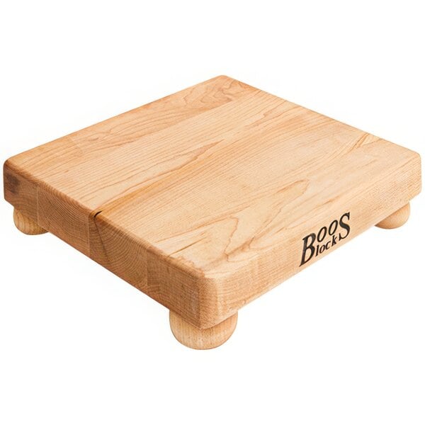 A John Boos maple wood cutting board with bun feet.