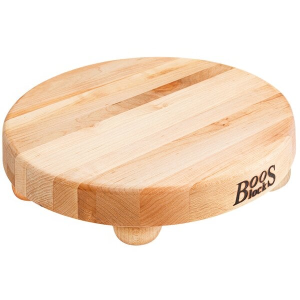 A John Boos round maple wood cutting board with bun feet.