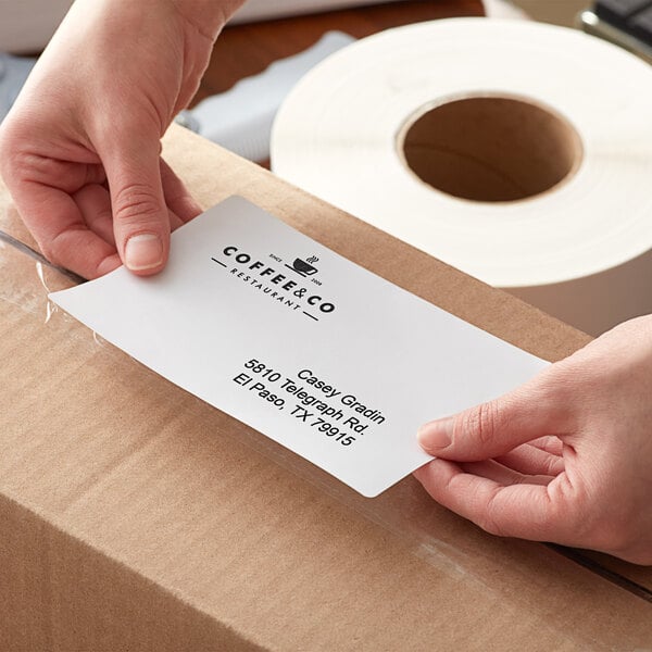 A person's hands holding a white Lavex Thermal Transfer label.