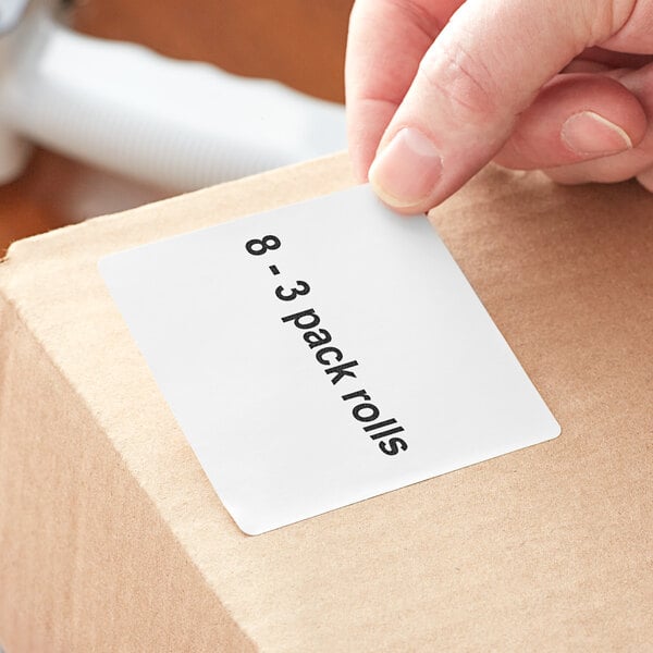 A person's hand holding a white box with a Lavex white label on it.