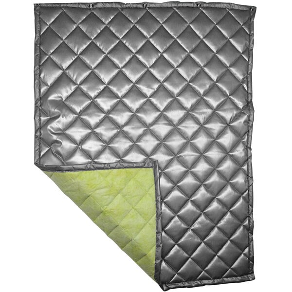 A white quilted blanket with a silver lining and green trim.