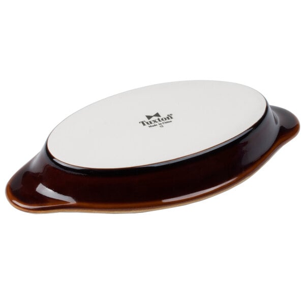 A white oval Tuxton Welsh Rarebit dish with brown accents.