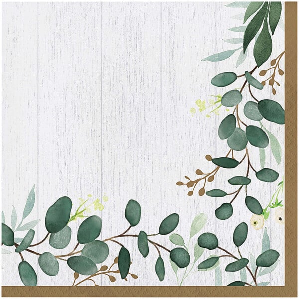 A Creative Converting Eucalyptus Green luncheon napkin with a painting of leaves and flowers on a white wood surface.