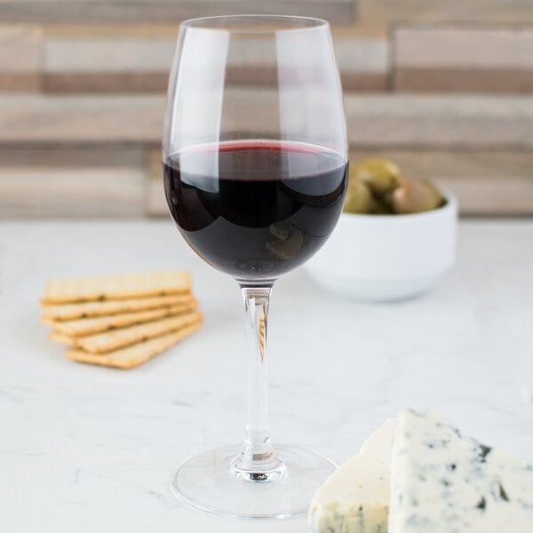 A Chef & Sommelier tall wine glass filled with wine next to crackers.