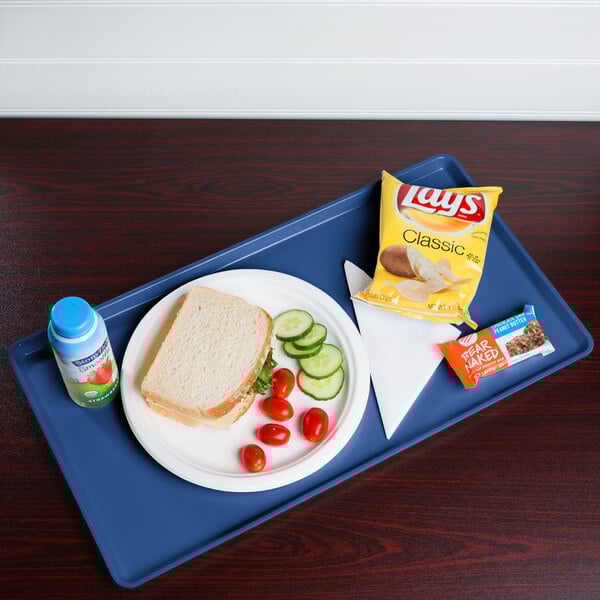 A Cambro dietary tray with a sandwich, chips, and a drink on it.